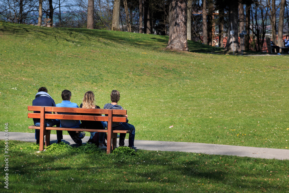 Sonne genießen in einem Park auf der Parkbank Sonne genießen in einem Park auf der Parkbank