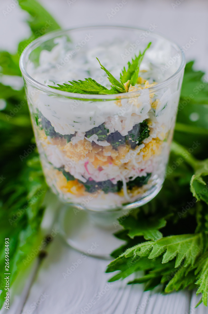 Exotic salad with nettles and eggs in a glass lined in layers. Exotic salad with nettles and eggs in a glass lined in layers.