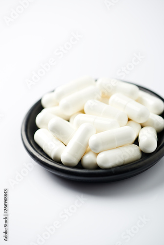 Creatine capsules. Bodybuilding food supplement on white background. 