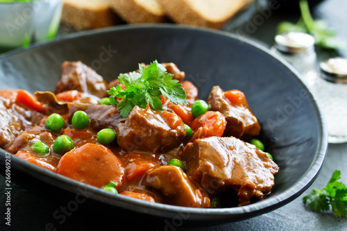 Beef stew in Burgundy. With carrots, onions, peas and champignons in wine. View from above.