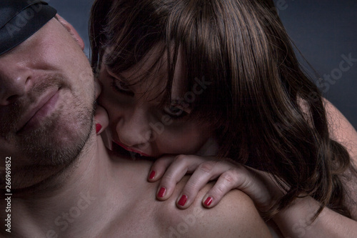 Canvas Print Female vampire bites man in the neck