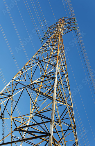 High voltage pylon against blue sky