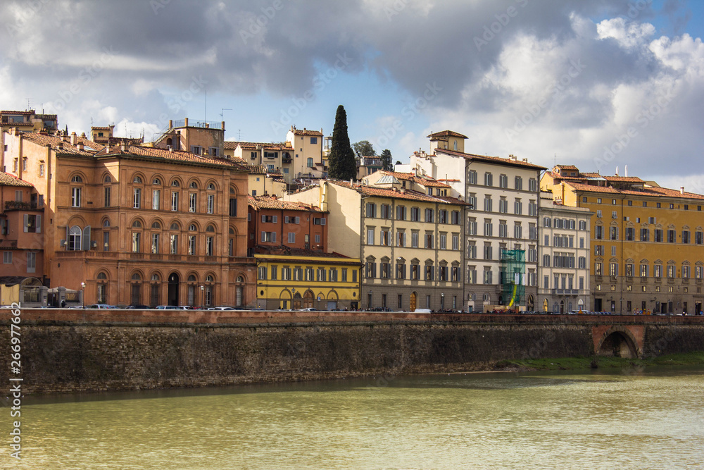 Amazing residential buildings on the embankment of river Arno in Florence, Italy. Different old facades, historical buildings, Italian Firenze architecture and shutter windows. Bright sunny day.