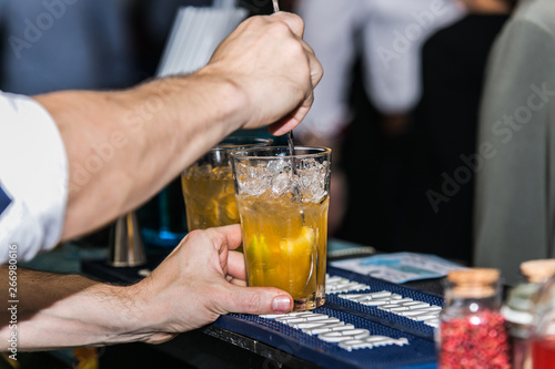 Closeup of barman hand putting on a glass to prepare cocktail.