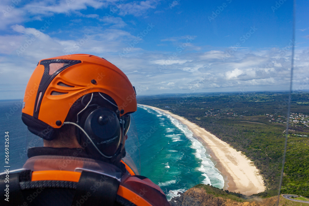 head of a pilot in a Gyrocopter with Wategoes Beach in the background, Byron Bay, Queensland, Australia