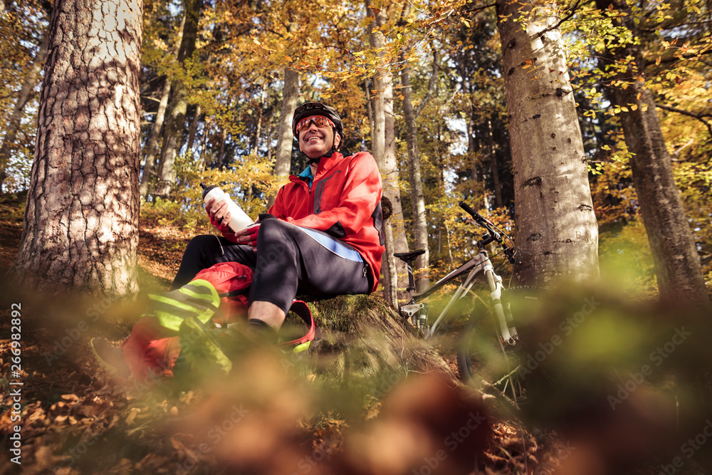 Man with mountain bike having a break in forest Man with mountain bike having a break in forest