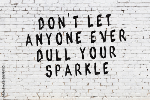 White brick wall with painted black motivational quote inscription