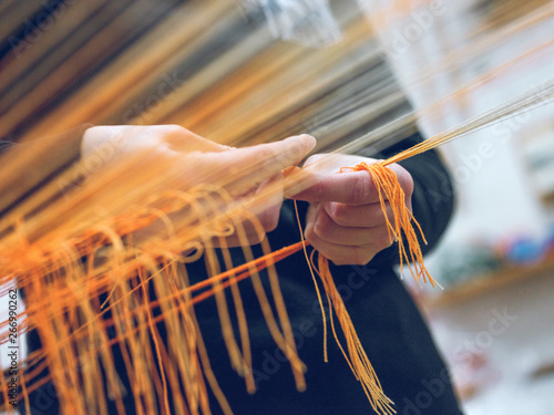 Crop person holding threads on loom photo