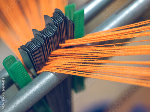 White and orange threads on loom photo