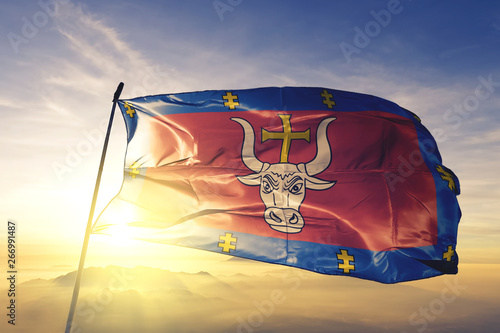 Quadro su tela Kaunas county of Lithuania flag waving on the top sunrise mist fog