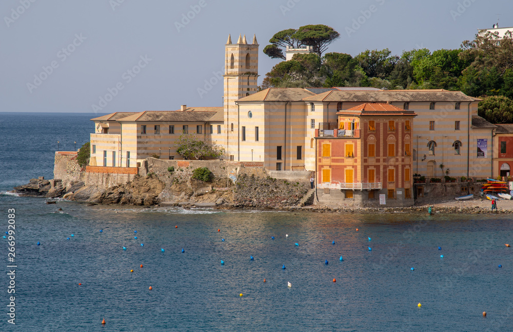 Elevated view of the Bay of Silence with the ancient Annunciation Monastery (1469)located on the extreme tip of the peninsula of Sestri Levante, in a sunny day with clear blue sky, Liguria, Italy