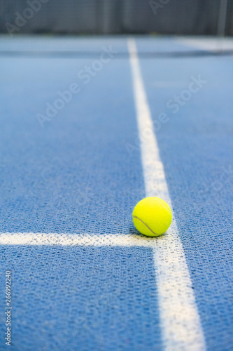 Tennis ball indoor on tennis court, white line, blue surface, copy space © milenie