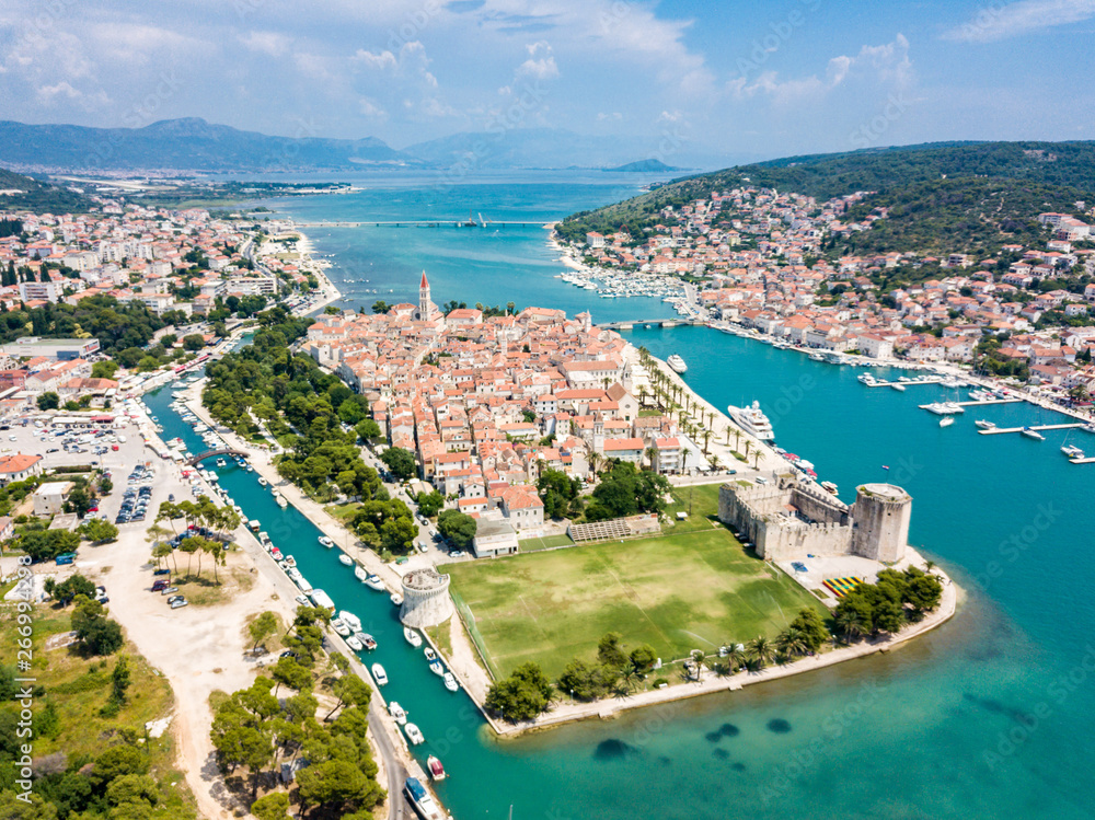 Aerial view of touristic old Trogir, historic town on a small island and harbour on the Adriatic coast in Split Dalmatia County, Croatia. Stone Kamerlengo Castle, medieval city walls and yachts marina