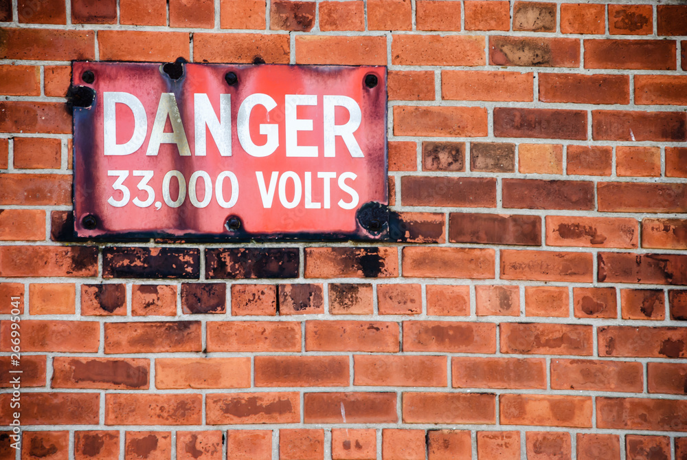 Obraz premium Warning sign outside an electricity substation saying 
