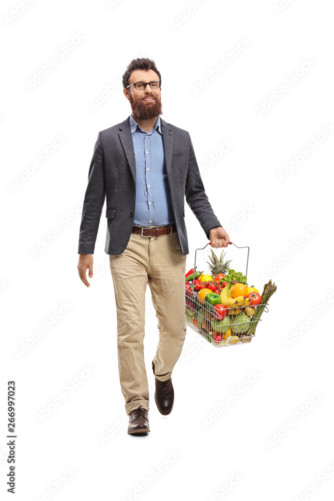 Bearded man walking with a shopping basket full of fruits and vegetables Bearded man walking with a shopping basket full of fruits and vegetables