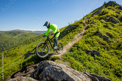Professional athlete is riding enduro bicycle on a beautiful rocky trail.