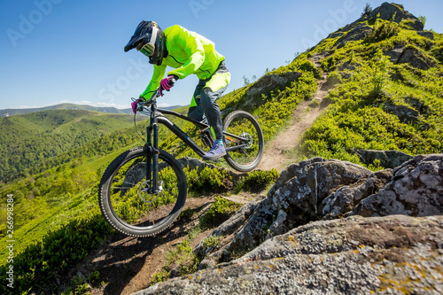 Professional athlete is riding enduro bicycle on a beautiful rocky trail. photo