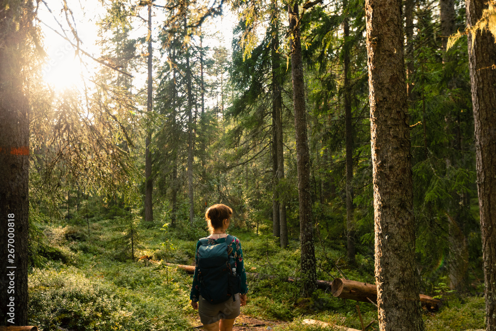 Woman with red hair and blue shirt walking in forest, close Woman with red hair and blue shirt walking in forest, close