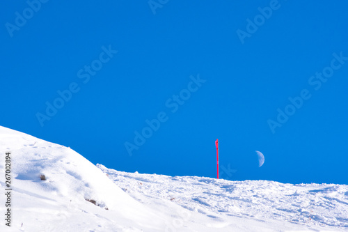 The Moon above a ski slope, Canazei, Italy