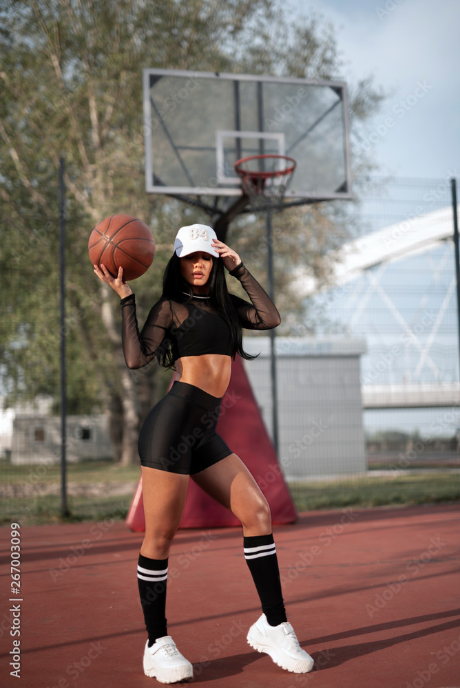 Sexy fitness model girl holding basketball on court Stock-Foto | Adobe Stock