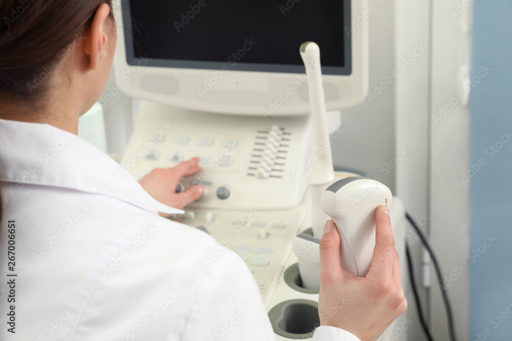 Professional sonographer using modern ultrasound machine in clinic, closeup Professional sonographer using modern ultrasound machine in clinic, closeup