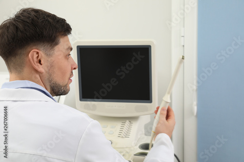 Professional sonographer using modern ultrasound machine in clinic