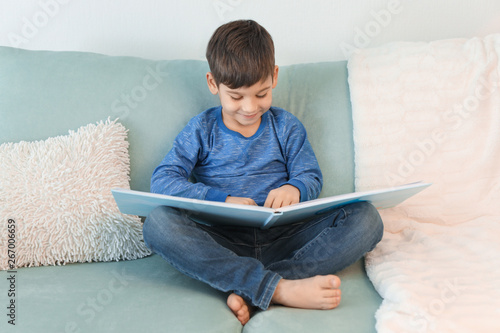 Cute little boy reading boo...