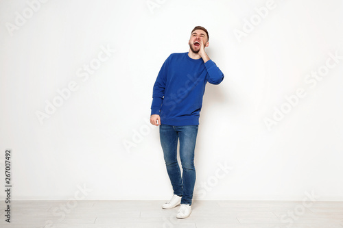 Full length portrait of emotional man against white wall photo