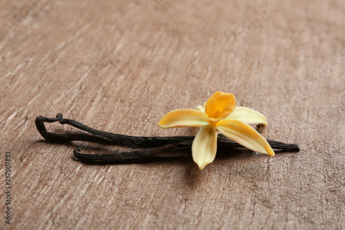 Vanilla sticks and flower on brown background. Space for text