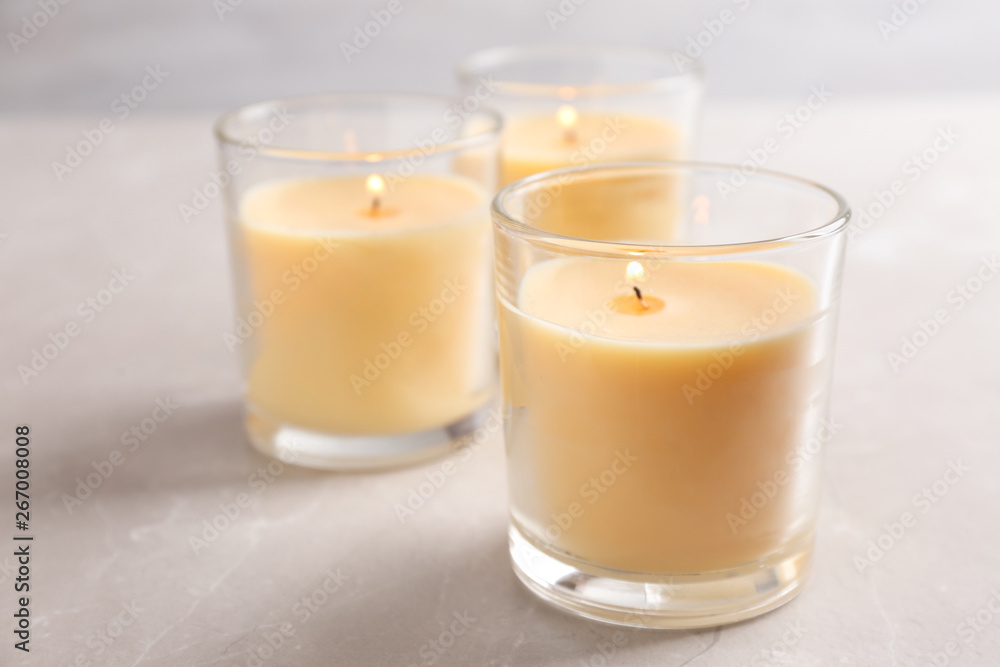 Three burning candles in glasses on table Three burning candles in glasses on table