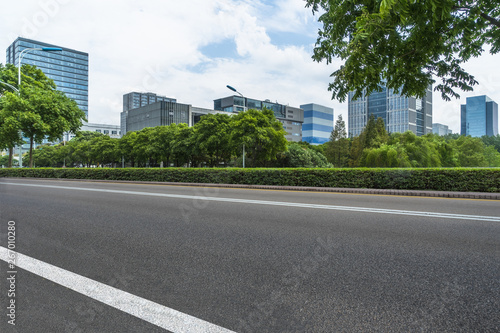 empty asphalt road near glass office building.