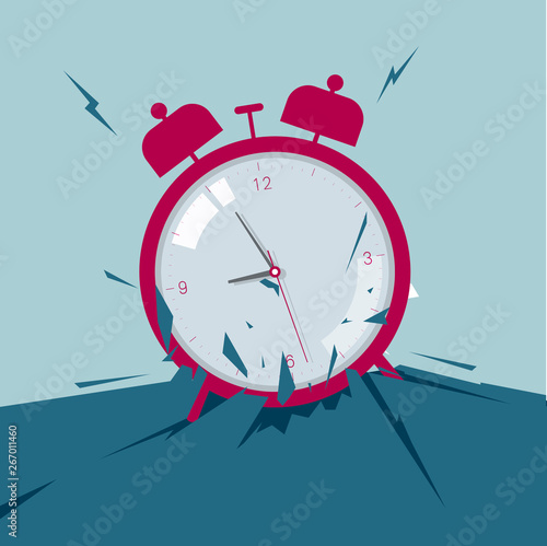 The alarm clock broke through the ground. Isolated on blue background.