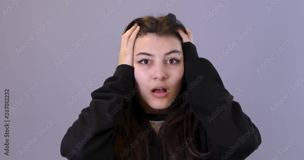 Close-up portrait teenage is nervous on isolated blue background Close-up portrait teenage is nervous on isolated blue background