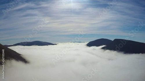 Time lapse of a huge cloud layer in the Cairngorms with the Munros mountains Cairn Toul, Sgor an Lochain Uaine and Ben Macdui peaking through in the Cairngorm Mountains in the Scottish Highlands. photo