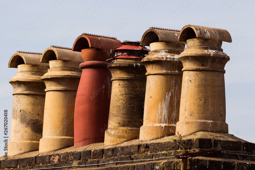 Φωτογραφία old chimneys of a roof of an old house in the UK