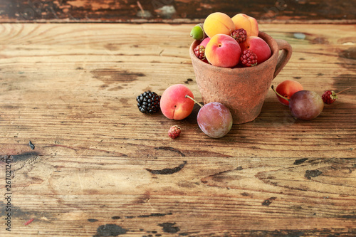 Vintage caramic mug full of colorful summer fruits photo