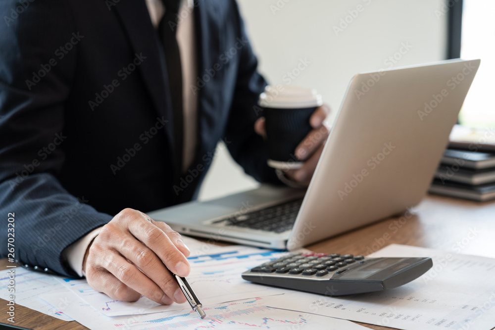 Fototapeta premium strategy analysis concept, Businessman working financial Manager Researching Process accounting calculate analyse market graph data stock information review on the table in office.