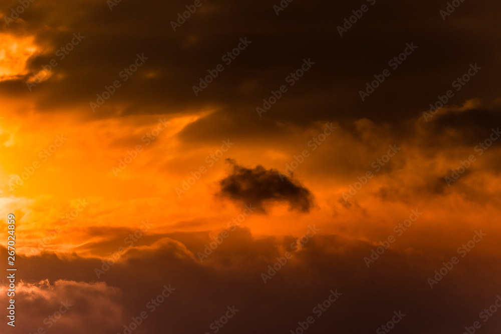 Twilight sky with effect of light pastel orange colors. Colorful sunset of soft clouds.