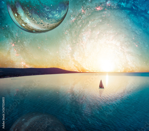 Dreamy fantasy landscape of lone sailboat sailing at sunset near coastline. Elements of this image furnished by NASA