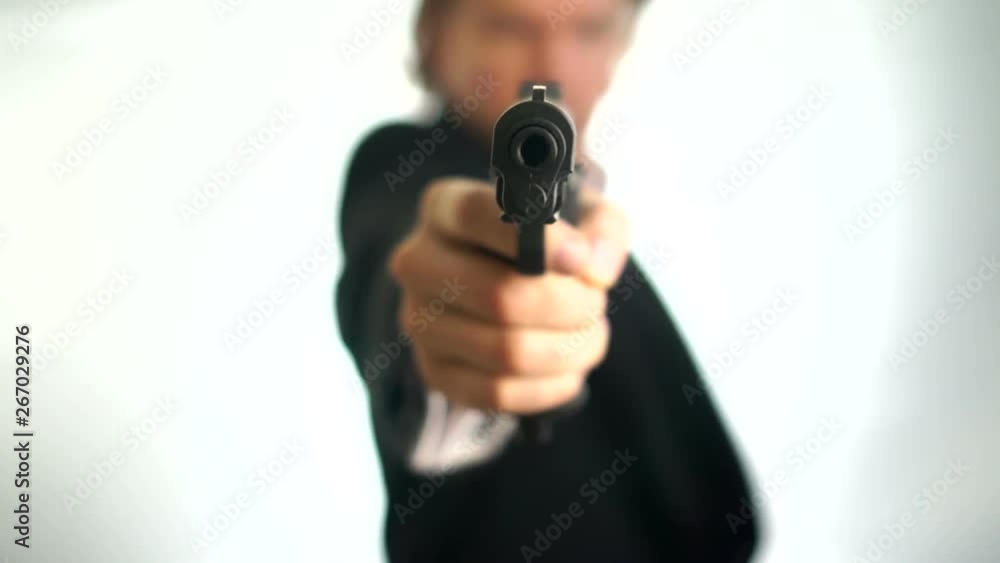 Gangster aim his gun at the camera.Man in suit aims his gun. A threatening stance, aiming down the sights of his pistol, police, mafia criminal or mercenary. Focus is on the barrel with a one hand pis Gangster aim his gun at the camera.Man in suit aims his gun. A threatening stance, aiming down the sights of his pistol, police, mafia criminal or mercenary. Focus is on the barrel with a one hand pis