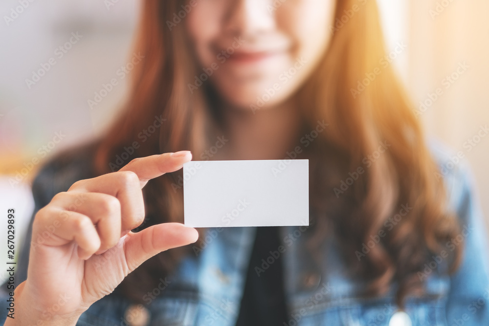 A beautiful woman holding and showing a blank empty business card to someone A beautiful woman holding and showing a blank empty business card to someone