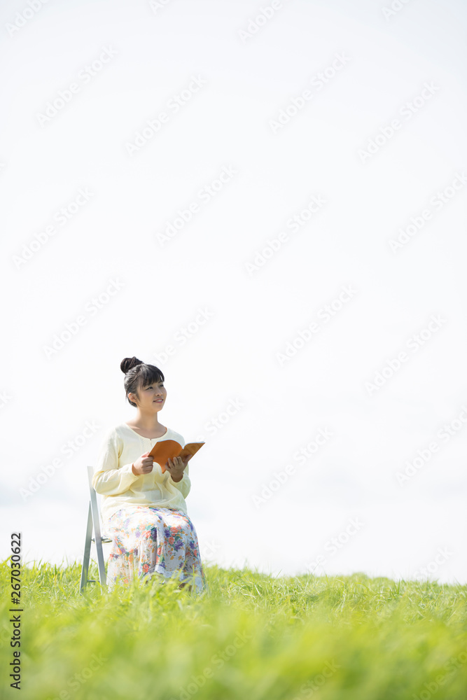 草原で本を読む女性