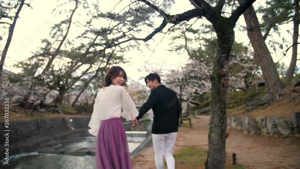 Japanese couple walking through beautiful river wide shot Japanese couple walking through beautiful river wide shot