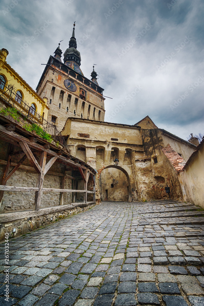 Cityscape of street with Clock Tower in old town Sighisoara, Romania