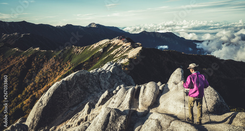 Epic adventure of hiker do trekking activity in mountain of Northern Japan Alps, Nagano, Japan, with panoramic nature mountain range landscape. Motivation leisure sport and discovery travel concept. photo