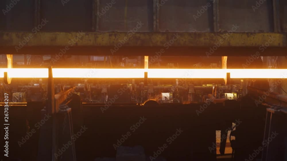 Steel mill, steel pipes production, red-hot pipe transported on production line, process of forming and cooling in heavy industry, rolled metal factory. Steel mill, steel pipes production, red-hot pipe transported on production line, process of forming and cooling in heavy industry, rolled metal factory.