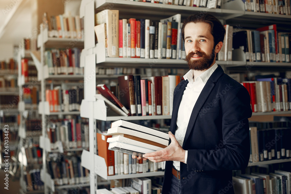 Man in a library. Guy in a black suit. Student with a books. Man in a library. Guy in a black suit. Student with a books.