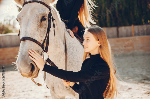 Fototapeta Naklejka Na Ścianę i Meble -  Girls with a horse. Women in a ranch. Blonde in a black sweater