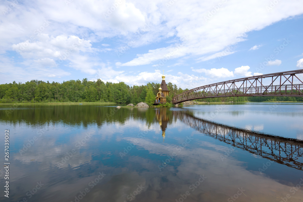 Fototapeta premium Panorama of the Vuoksa River overlooking the Church of St. Andrew the First Called on a sunny summer day. Leningrad region, Russia