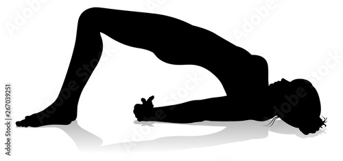 A silhouette of a woman in a yoga or pilates pose 